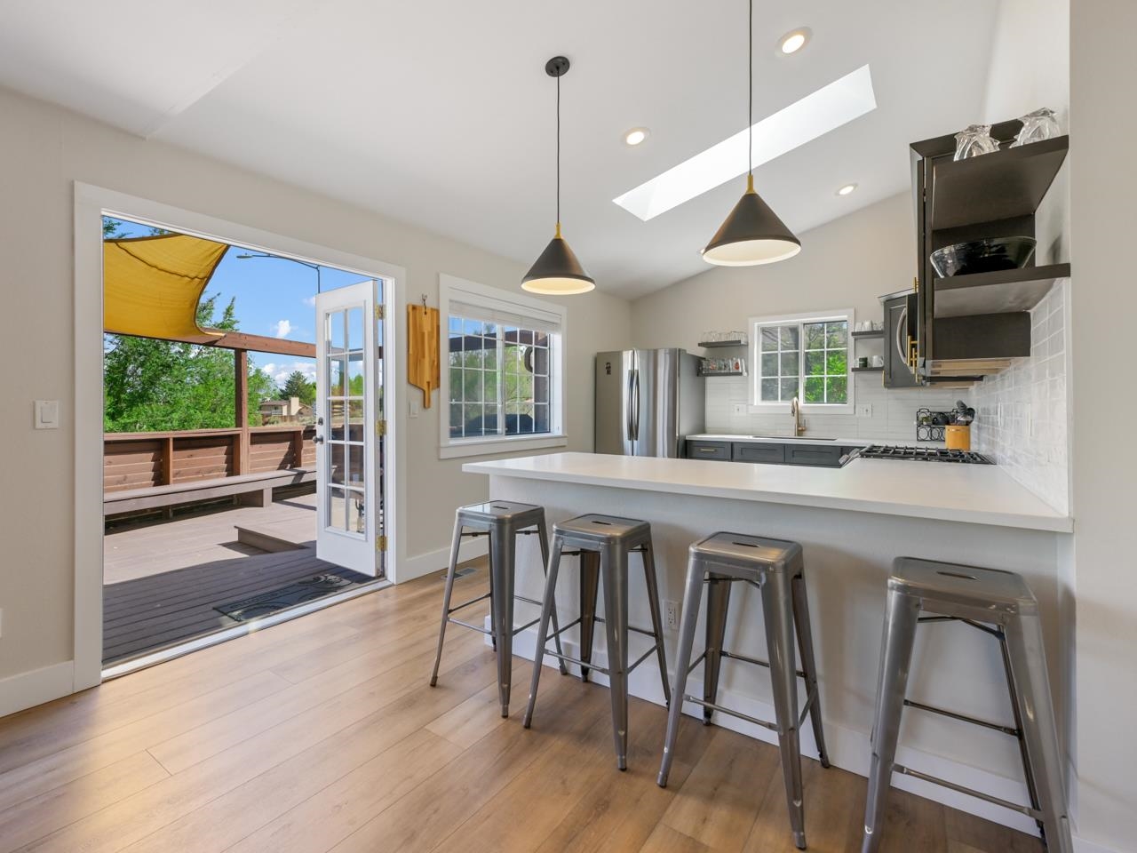 383 Explorer Court, Unit B Grand Junction, CO 81507 - Photo 11 of 40 a kitchen with stainless steel appliances granite countertop a stove top oven a sink a dining table and chairs with wooden floor
