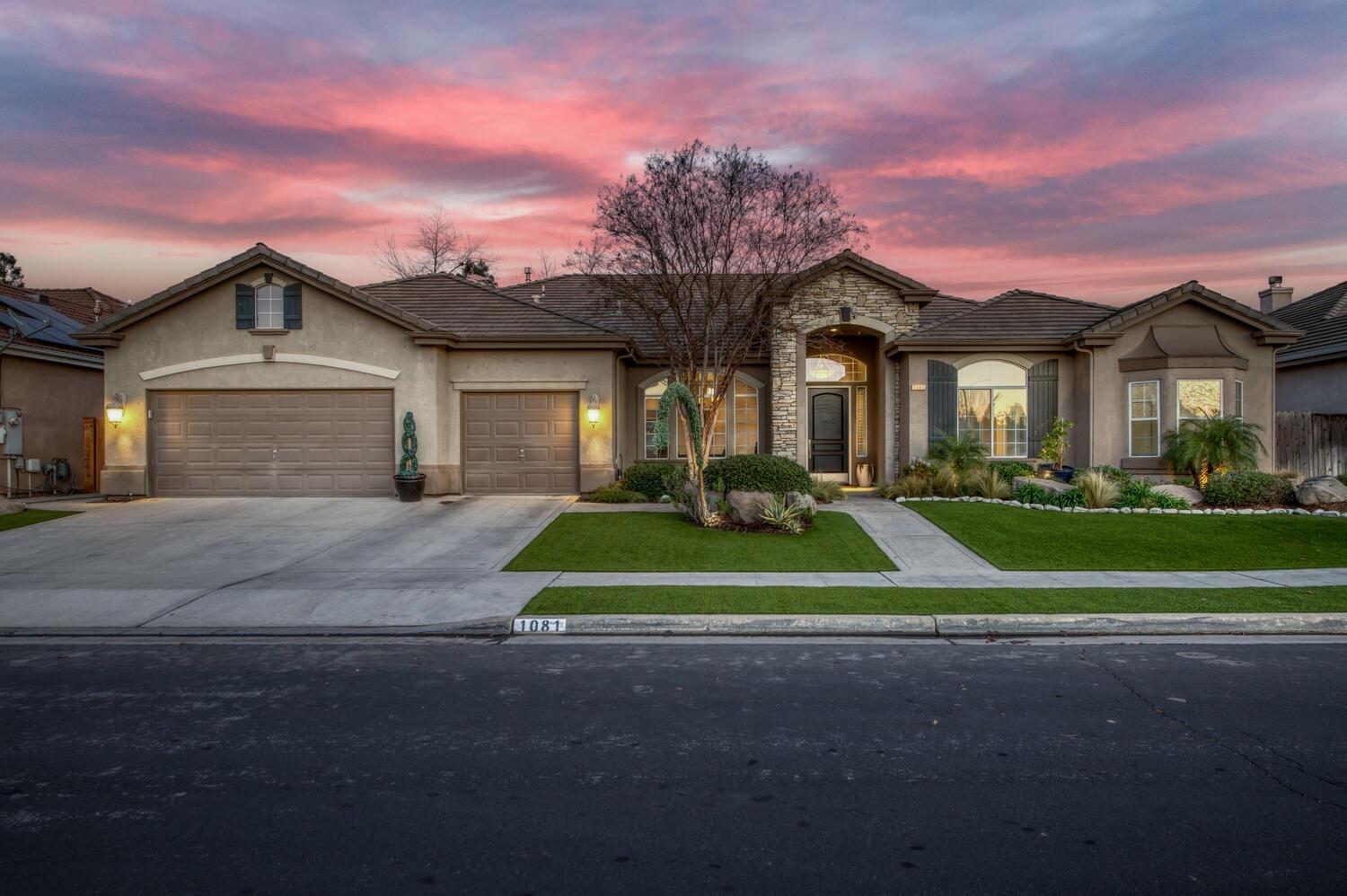 a front view of a house with a yard and palm trees