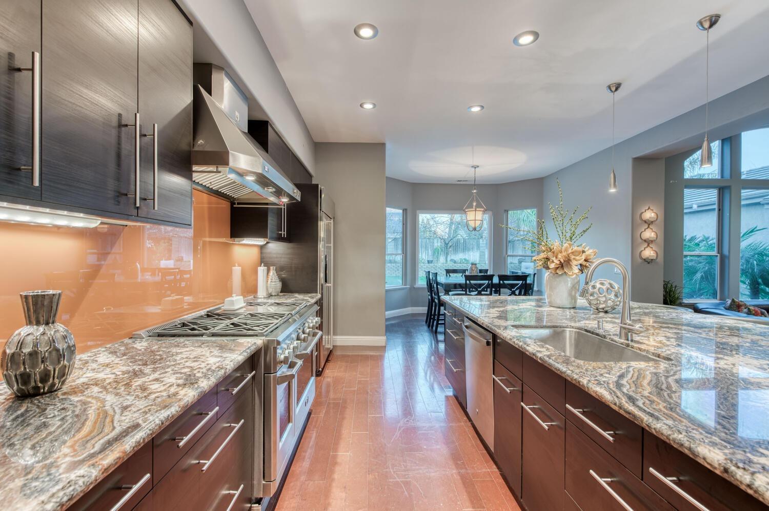 1081 North Harvard Avenue Clovis, CA 93611 - Photo 17 of 57 a kitchen with stainless steel appliances granite countertop a lot of counter space and wooden floors