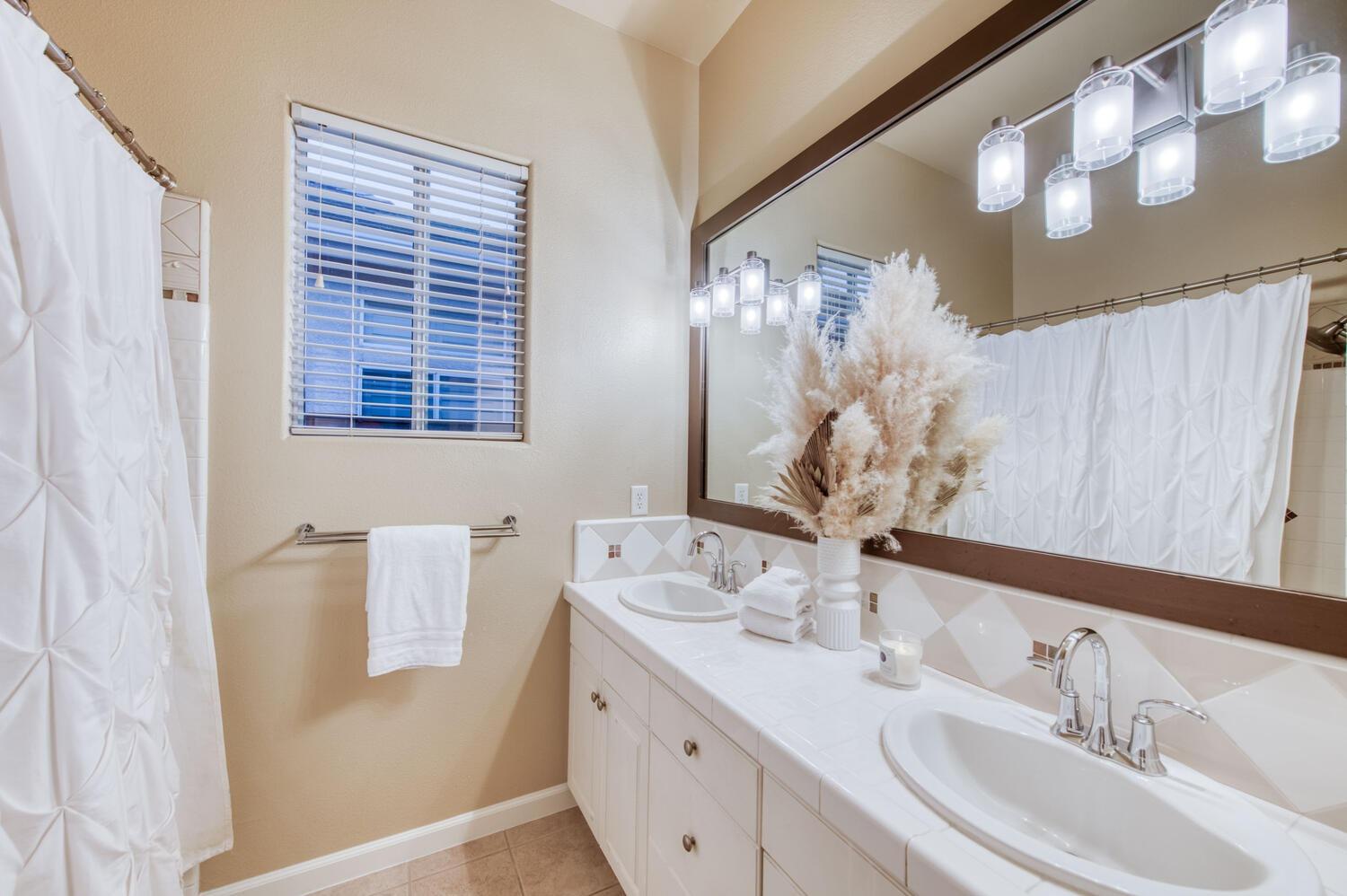 1081 North Harvard Avenue Clovis, CA 93611 - Photo 29 of 57 a bathroom with a double vanity sink and a mirror