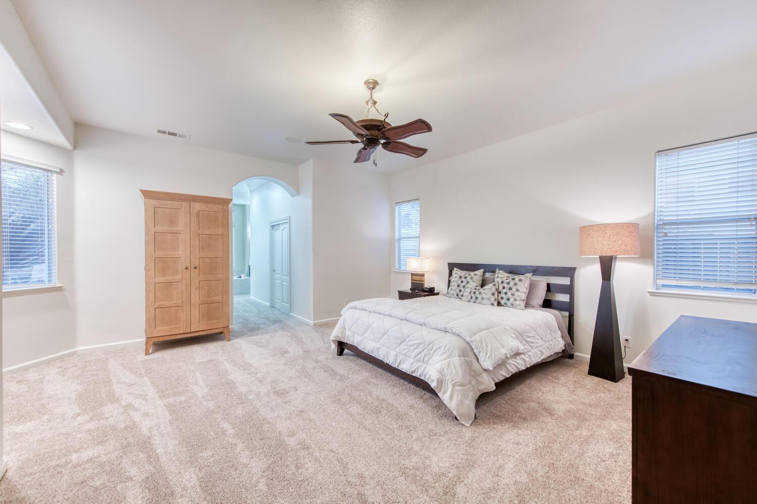 1081 North Harvard Avenue Clovis, CA 93611 - Photo 31 of 57 a spacious bedroom with a bed and a chandelier