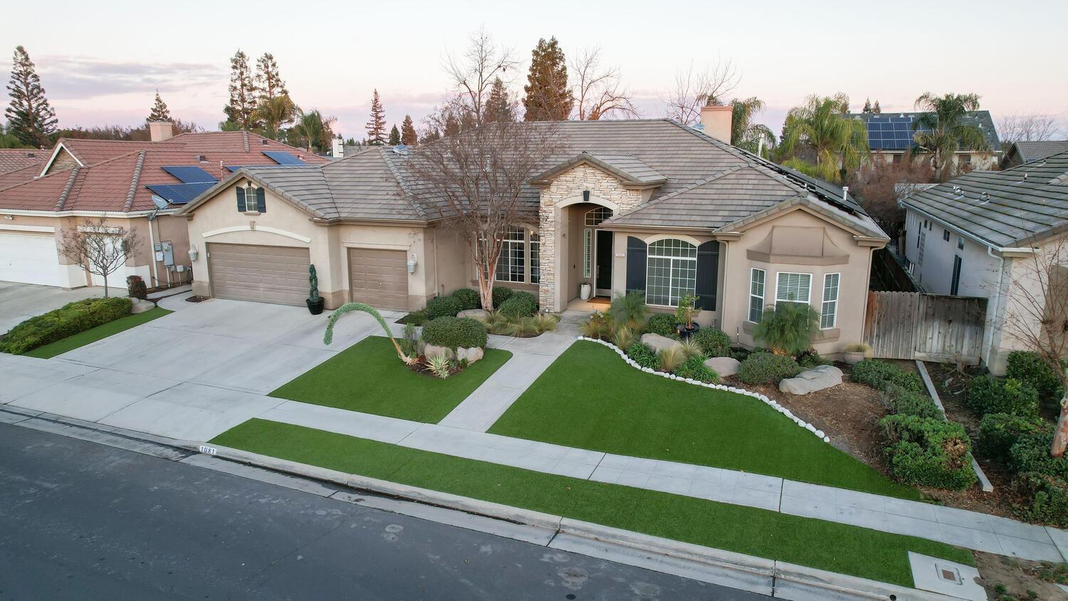 1081 North Harvard Avenue Clovis, CA 93611 - Photo 48 of 57 a front view of a house with a yard and garage