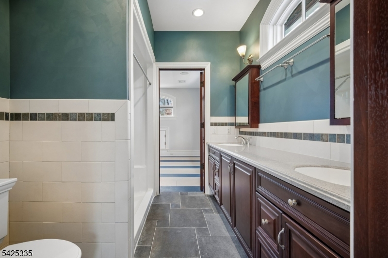 318 Franklin Road Denville, NJ 07834 - Photo 20 of 40 a bathroom with a granite countertop sink a toilet a mirror and shower
