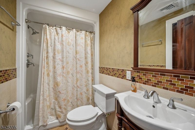 318 Franklin Road Denville, NJ 07834 - Photo 22 of 40 a bathroom with a sink a toilet and shower curtain