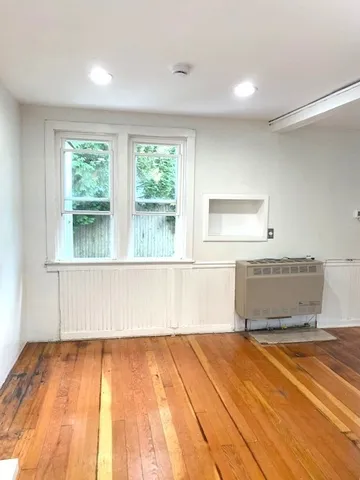 a view of a room with wooden floor and window
