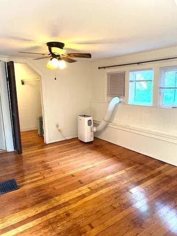 a view of a room with wooden floor and window