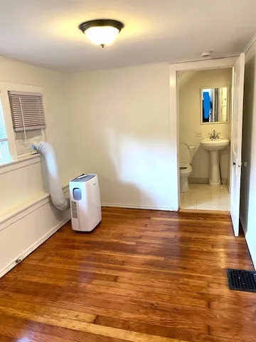 a view of a room with wooden floor and furniture