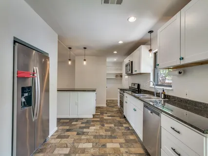 a kitchen with stainless steel appliances granite countertop a refrigerator and a sink