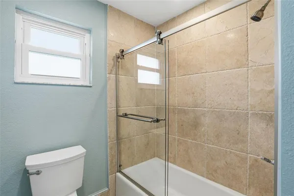 a bathroom with a shower a toilet and a sink