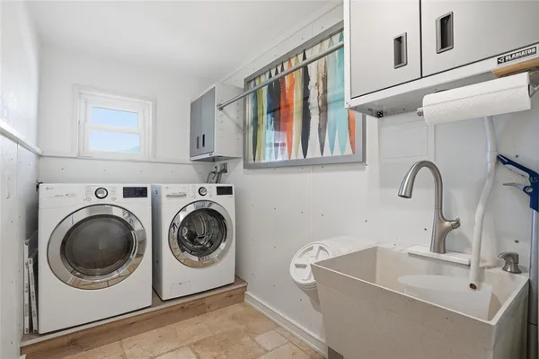 a utility room with sink dryer and washer