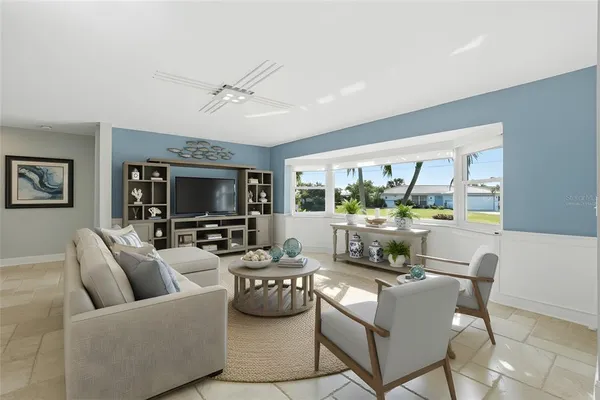 a living room with furniture a flat screen tv and a large window