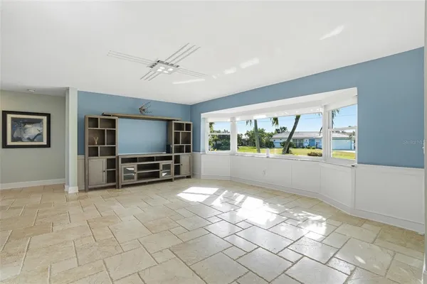 a living room with furniture a flat screen tv and a floor to ceiling window