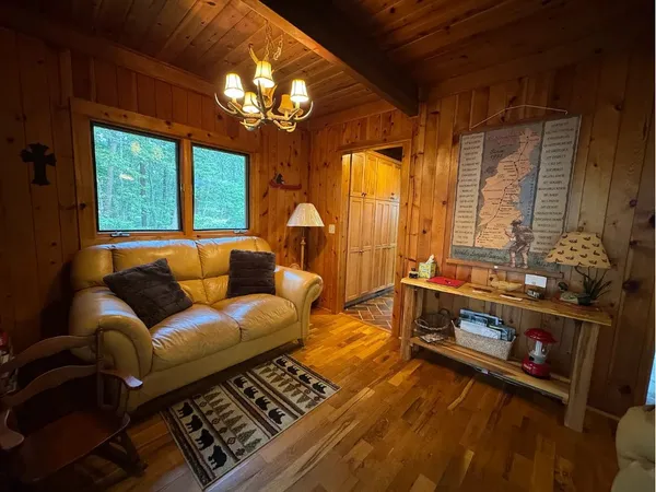 a living room with furniture a chandelier and a flat screen tv
