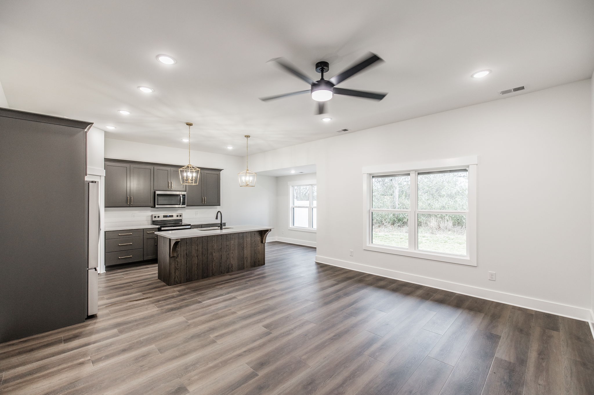 2157 Rylee Way Greenbrier, TN 37073 - Photo 12 of 35 a large kitchen with a wooden floor a large window and stainless steel appliances