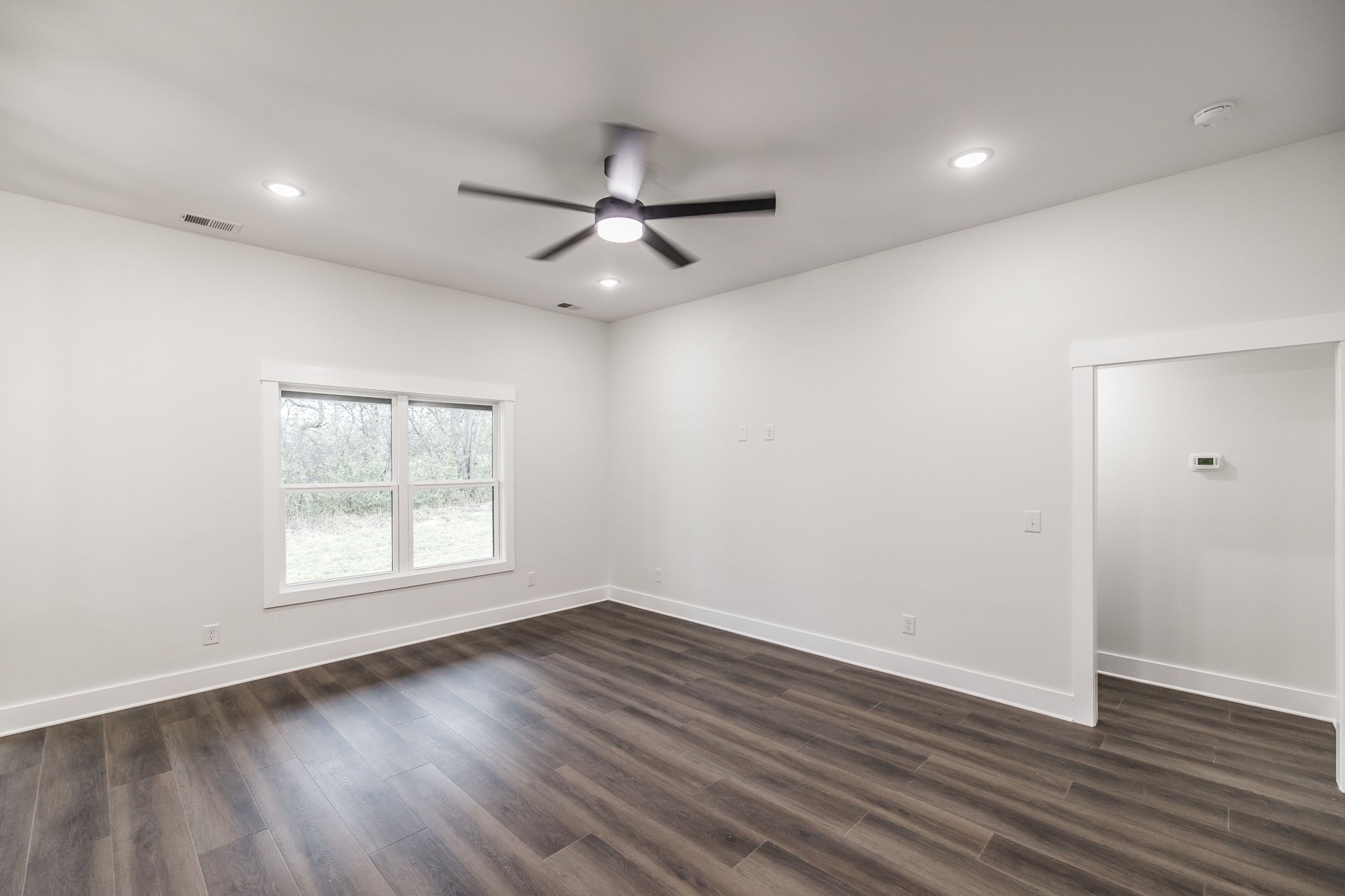 2157 Rylee Way Greenbrier, TN 37073 - Photo 18 of 35 an empty room with wooden floor a ceiling fan and windows