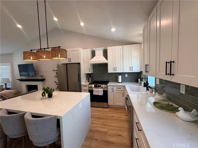 a kitchen with stainless steel appliances a sink stove and refrigerator
