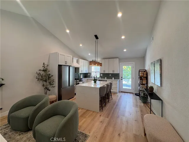 a living room with furniture and a dining table with kitchen view