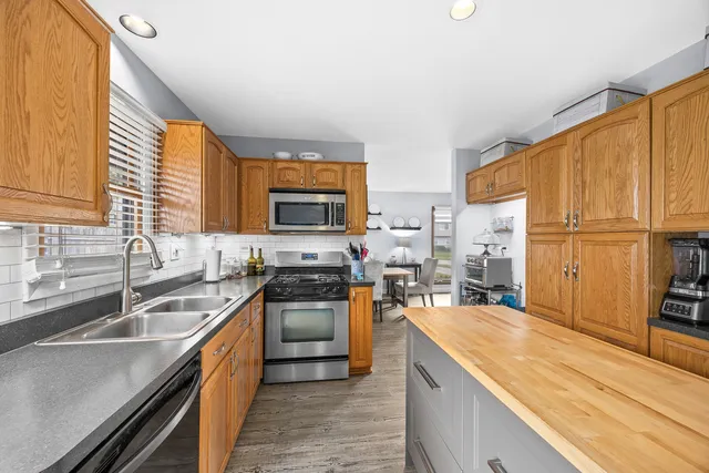 a kitchen with stainless steel appliances granite countertop sink stove top oven and cabinets