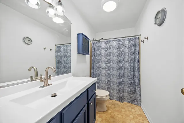 a bathroom with a sink a toilet a mirror and shower