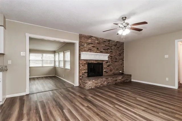 a view of an empty room with a fireplace and a window