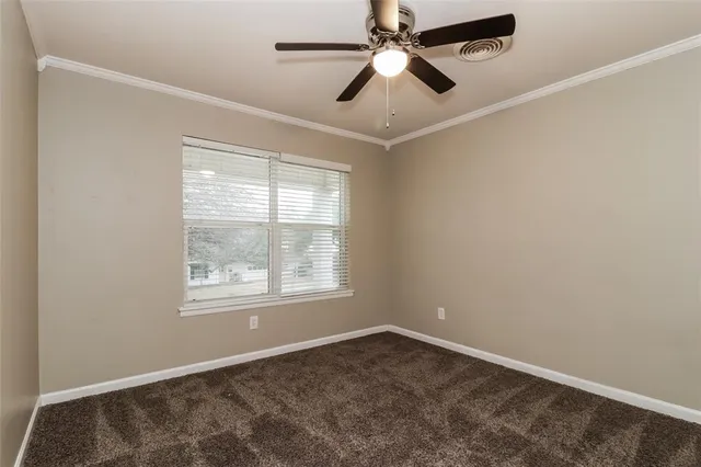 an empty room with a window and a fan
