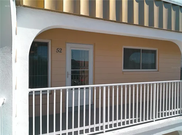 an empty room with chandelier fan and windows