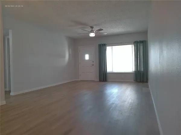 a view of empty room with wooden floor