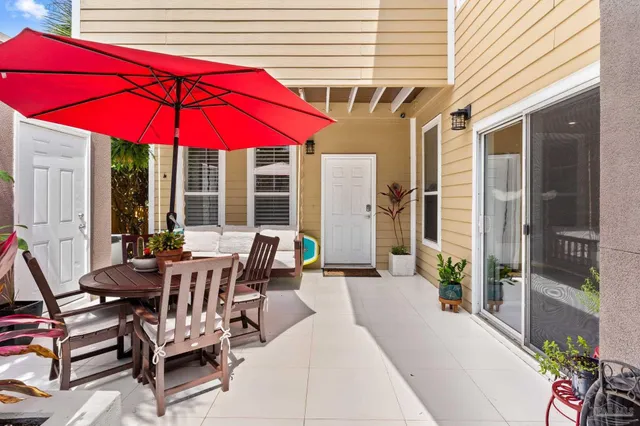 a patio with a table and chairs under an umbrella