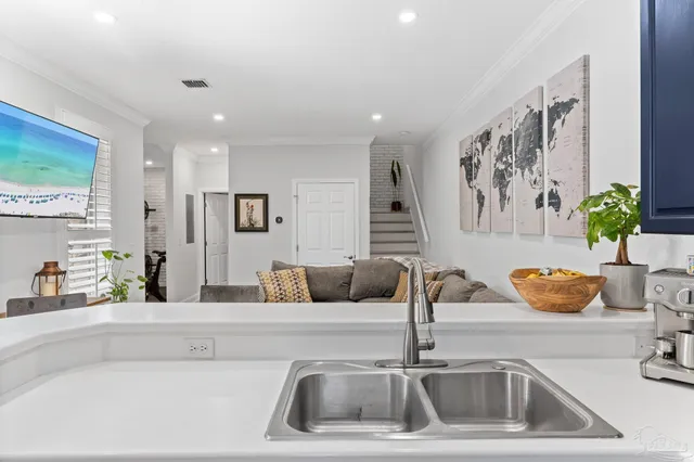 a kitchen with a sink and a wooden floor