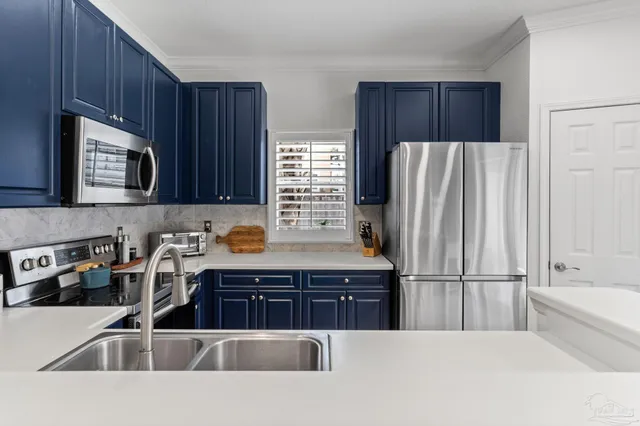 a kitchen with stainless steel appliances a refrigerator a sink a stove a microwave a sink and cabinets