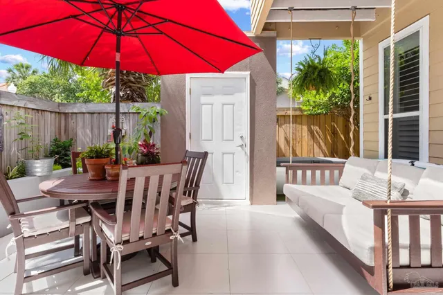 a view of a patio with a table and chairs under an umbrella