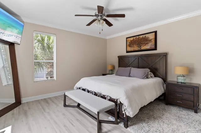 a bedroom with a bed a chandelier and a window