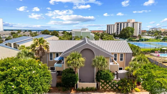 a view of a house with a yard and potted plants