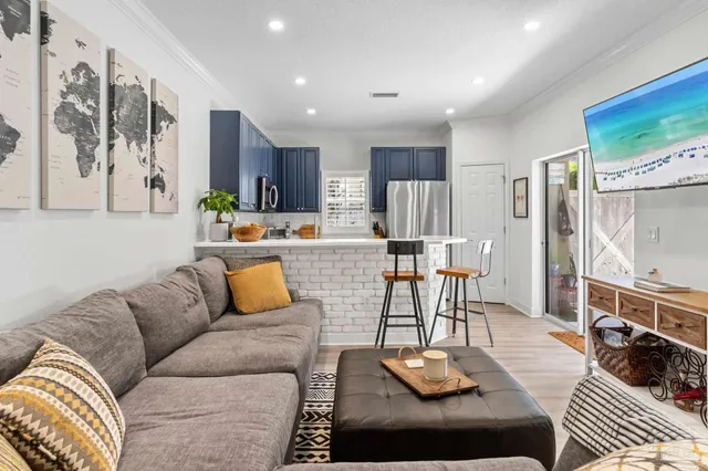a living room with stainless steel appliances furniture and a table