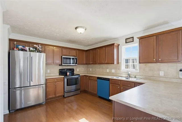 a kitchen with a sink a refrigerator and cabinets