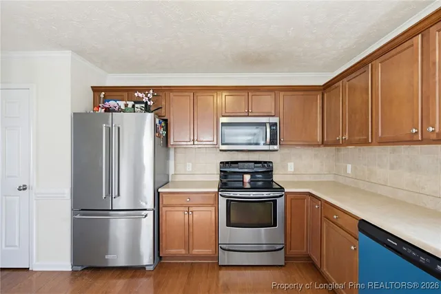 a kitchen with a refrigerator stove and white cabinets