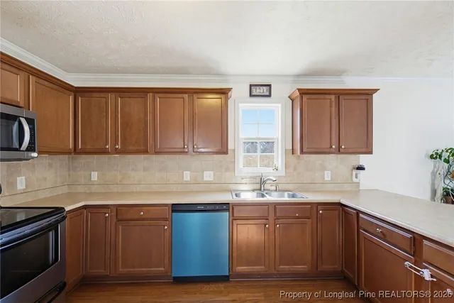 a kitchen with stainless steel appliances granite countertop a sink stove and cabinets