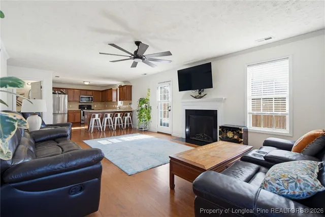 a living room with furniture a flat screen tv and a fireplace