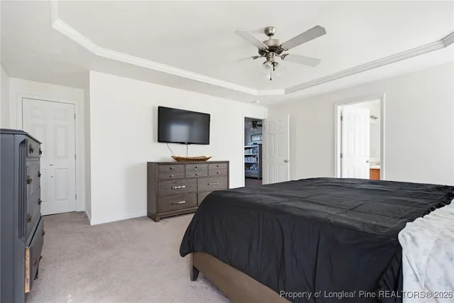 a bedroom with a bed and a flat tv screen on dresser