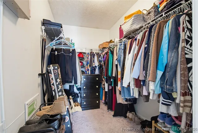 a view of walk in closet with clothes and shoes