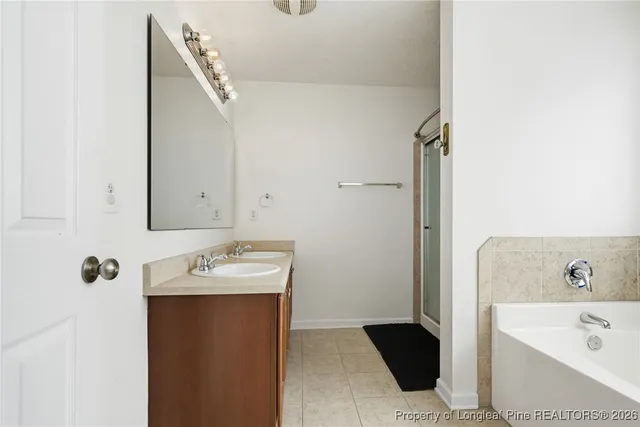 a bathroom with a bathtub sink and mirror