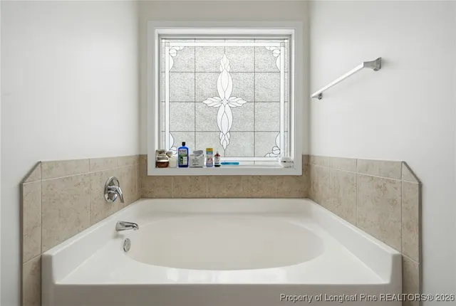 a bathroom with bathtub and window