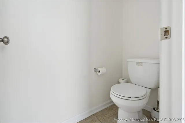 a white toilet sitting next to a white wall
