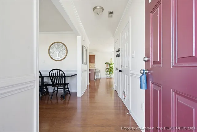 a view of a hallway with wooden floor and furniture