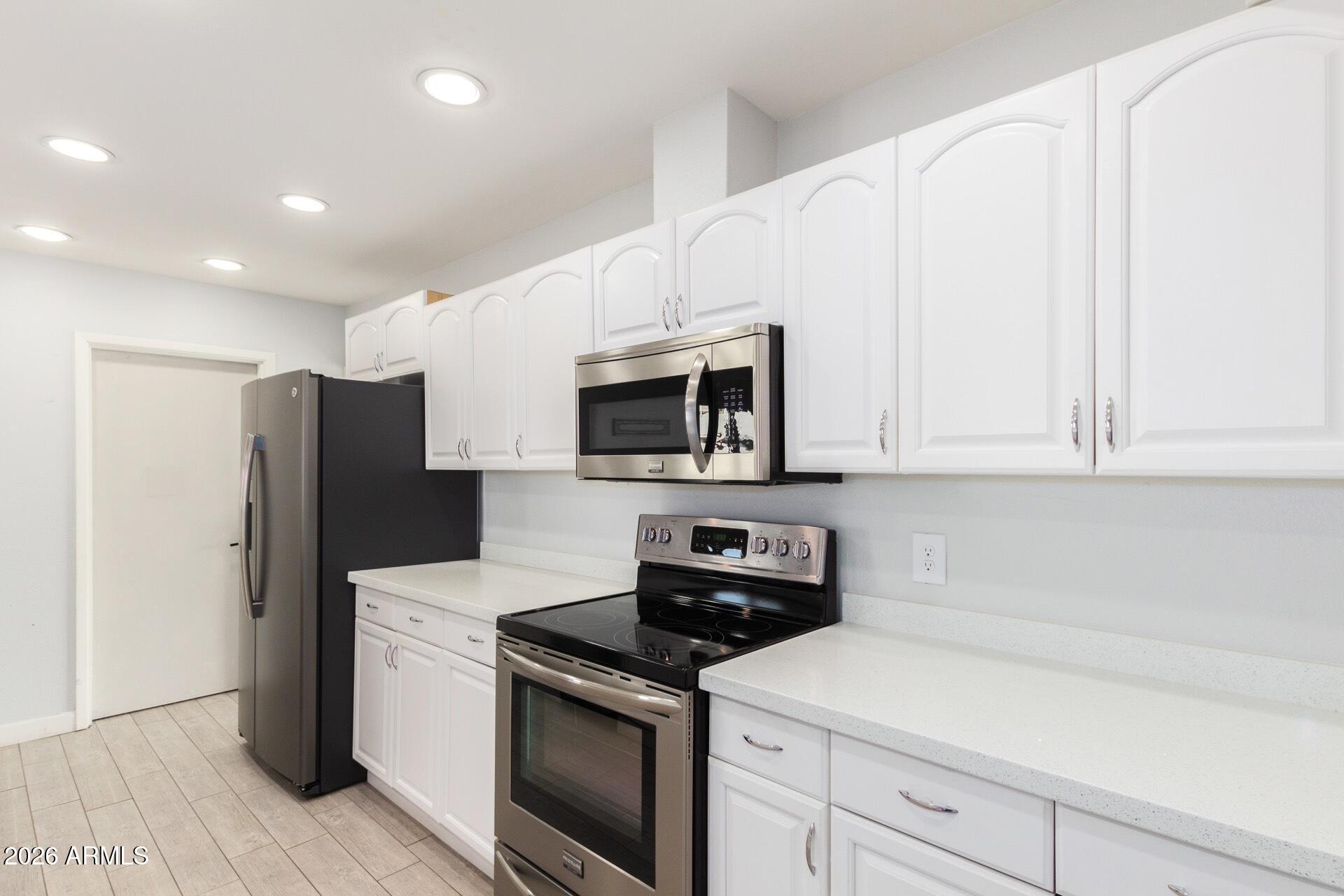 860 West McLellan Road Mesa, AZ 85201 - Photo 2 of 26 a kitchen with stainless steel appliances granite countertop white cabinets a microwave a sink and a refrigerator