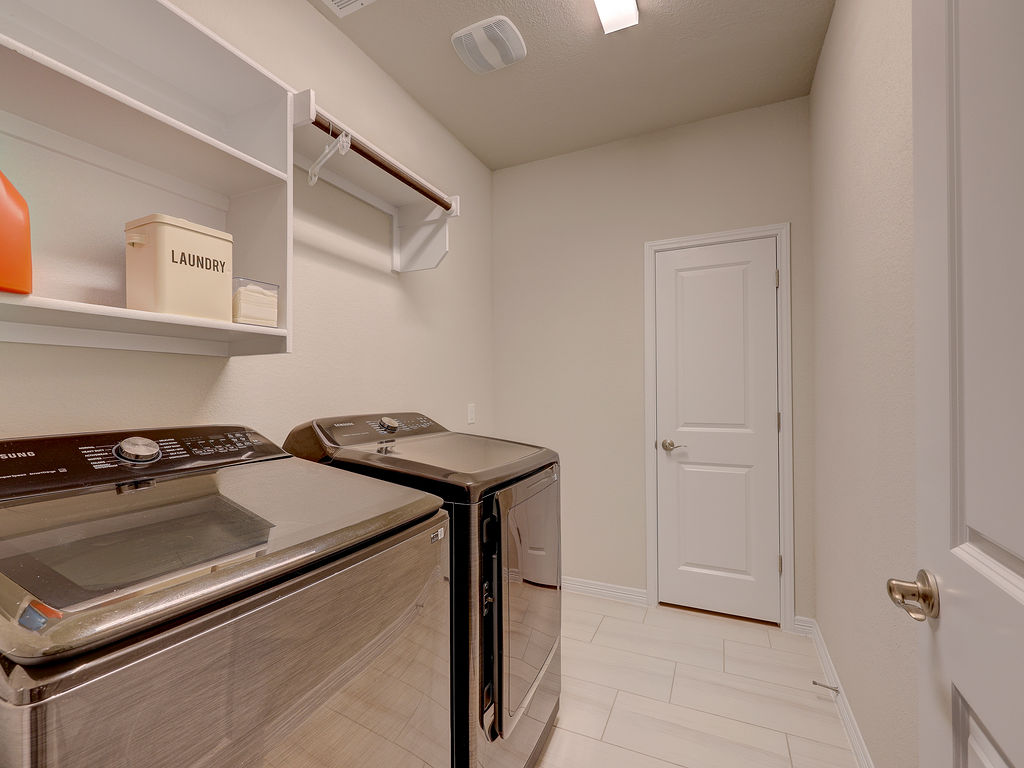 229 Heartleaf Road San Marcos, TX 78666 - Photo 32 of 40 A dedicated laundry space boasts shelving and hanging rod for ultimate convenience.