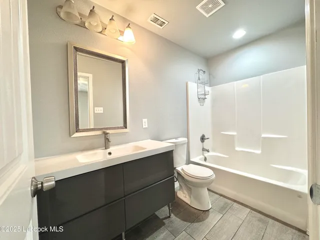 a bathroom with a double vanity sink toilet mirror and bathtub