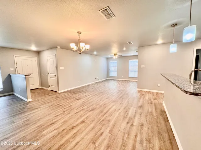a view of a kitchen with a sink and wooden floor