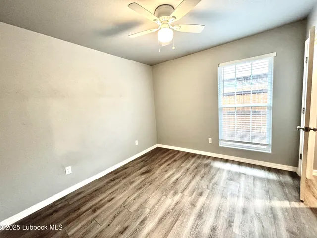 a view of an empty room and chandelier fan