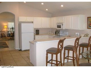 17732 Oakmont Ridge Circle Fort Myers, FL 33967 - Photo 2 of 7 a kitchen with a table chairs refrigerator and cabinets